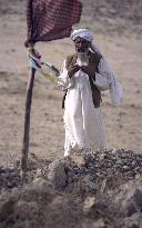 An elderly Afghan man prays Nov. 1 in front of tombs